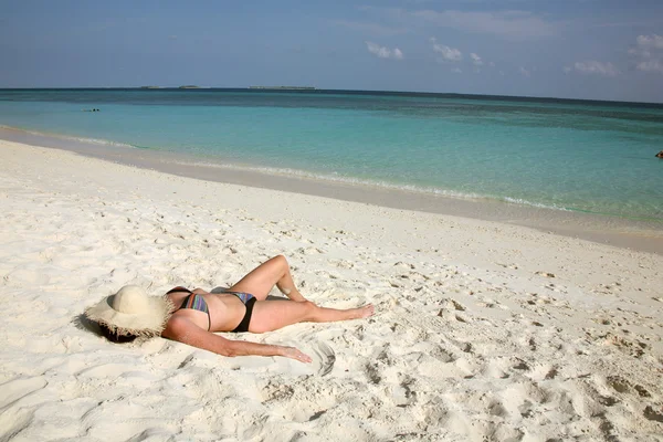 Vrouw slaapt op strand met zon hoed over gezicht — Stockfoto