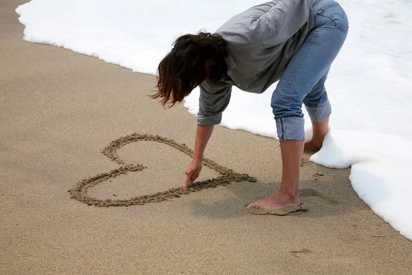 V lásce - malování srdcí na pláži — Stock fotografie