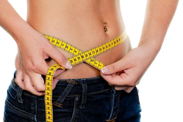Slim woman with measuring tape measure her figure — Zdjęcie stockowe