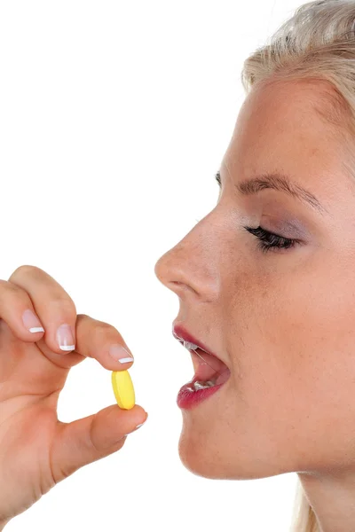 Uma jovem toma um comprimido — Fotografia de Stock