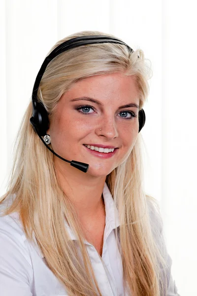 Donna con auricolare telefonico in un call center — Foto Stock
