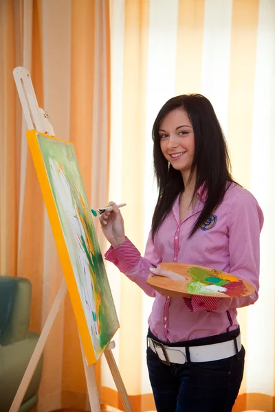 Young girl painting on an easel — Stock Photo, Image