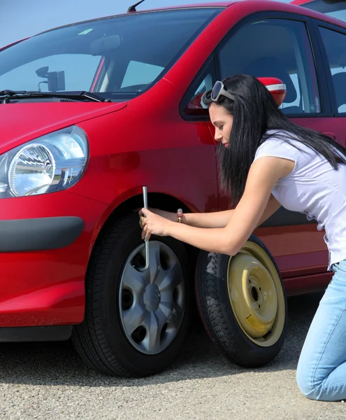 Vrouw met een lekke band op auto — Stockfoto