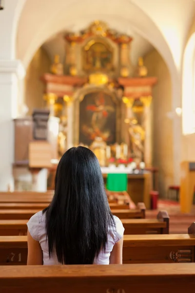 Женщина, молящаяся в церкви — стоковое фото
