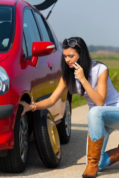 Mujer con un neumático pinchado en el coche —  Fotos de Stock