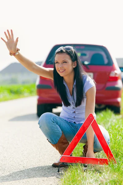 Žena s červený výstražný trojúhelník pro případ poruchy — Stock fotografie