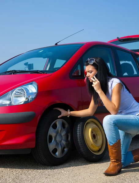Žena s prázdnou pneumatiku na auto — Stock fotografie