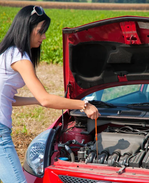 Paní opatření tlak oleje v jejím autě — Stock fotografie