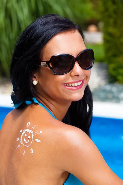 Femme avec crème solaire à la piscine — Photo