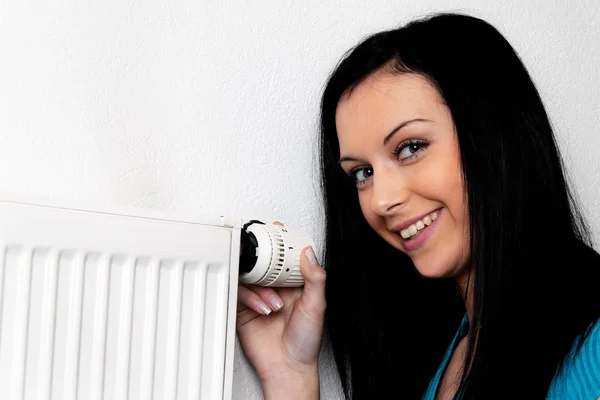 Mulher com um aquecedor e termostato — Fotografia de Stock