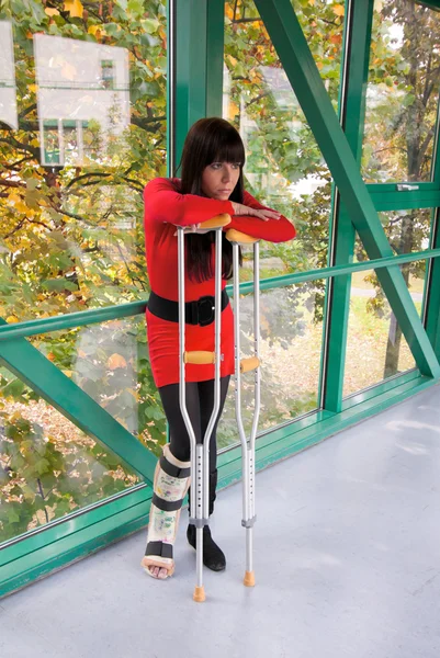 Kvinna med benet i gips och kryckor på sjukhus — Stockfoto