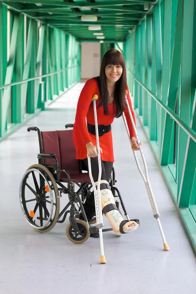 Woman with leg in plaster and crutches — Stock Photo, Image