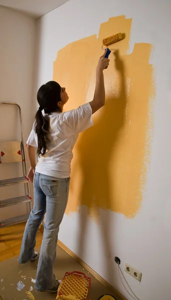 Kvinna färger sin första lägenhet — Stockfoto
