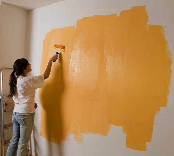 Kvinna färger sin första lägenhet — Stockfoto
