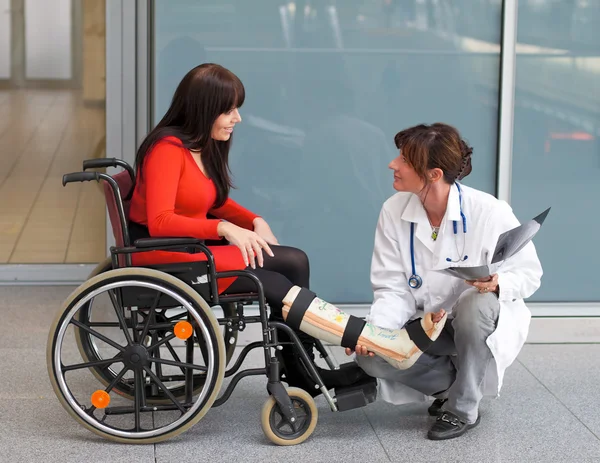 Mujer con pierna en yeso, médico y silla —  Fotos de Stock