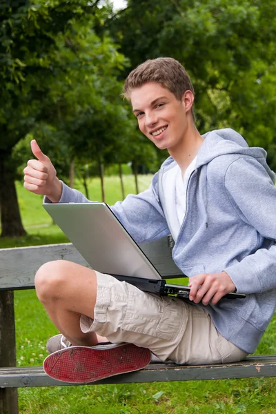 屋外のラップトップ コンピューターと若い男 — ストック写真