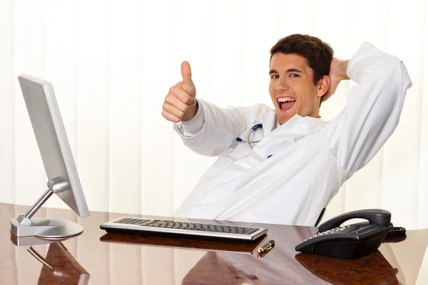 Successful doctor sits at desk — Stock Photo, Image