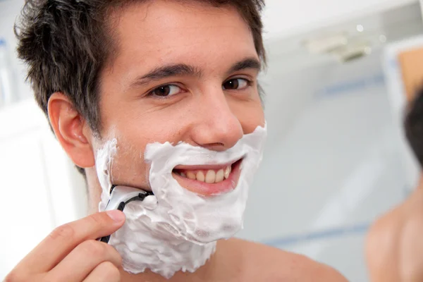 Stock image Man shaves with a razor blade