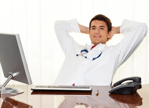 Successful doctor sits at desk — Stock Photo, Image