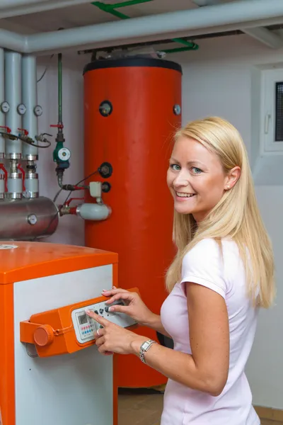 Vrouw in de boilerkamer voor verwarming — Stockfoto