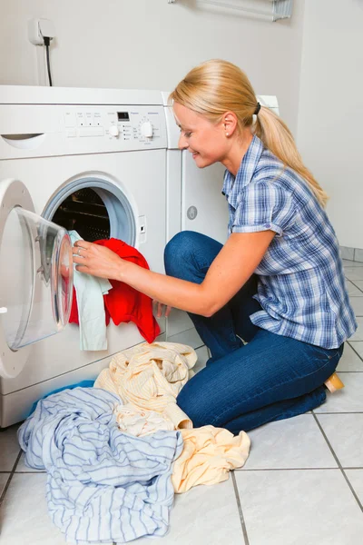 Dona de casa com máquina de lavar roupa e roupa — Fotografia de Stock