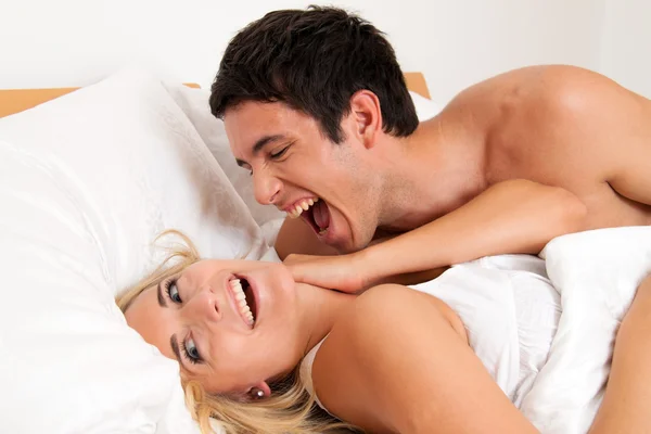 Casal se diverte na cama — Fotografia de Stock