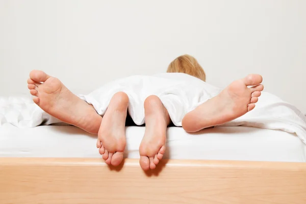 Pés de casal na cama . — Fotografia de Stock