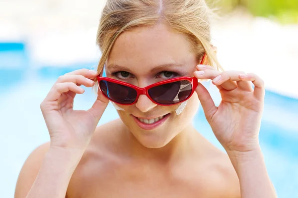 Kvinna med solglasögon och solkräm — Stockfoto