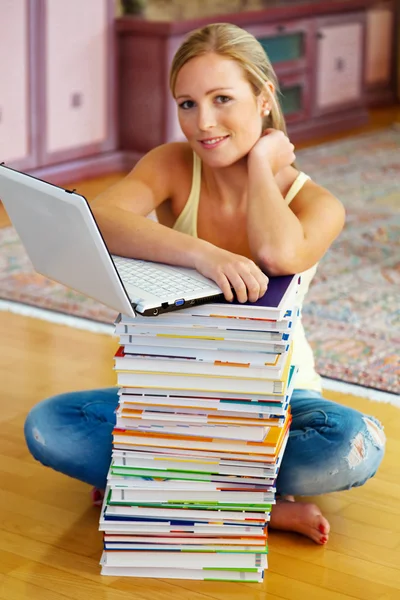 Студент со стопкой книг и компьютеров — стоковое фото