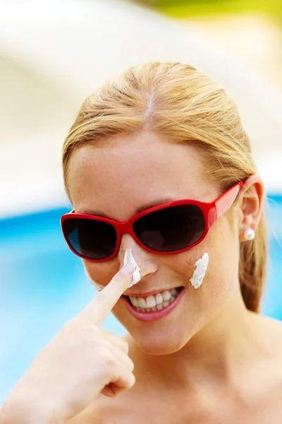 Vrouw met zonnebril en zonnebrandcrème — Stockfoto