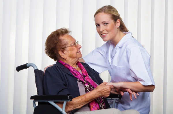 Krankenschwester und die alte Frau im Rollstuhl — Stockfoto