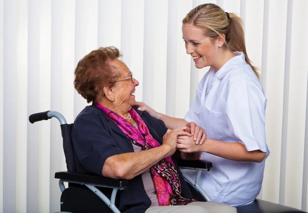 Infirmière et la vieille femme en fauteuil roulant — Photo