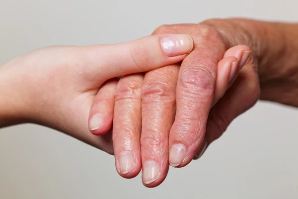 Velho e jovem mão com bengala — Fotografia de Stock