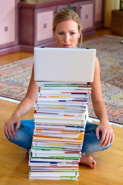 書籍やコンピューターのスタックを持つ学生 — ストック写真