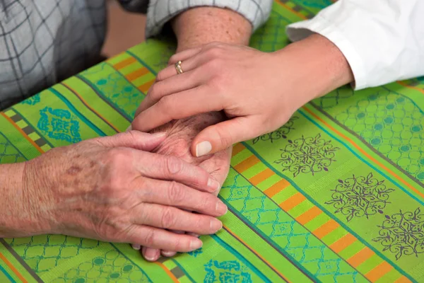 Hand of a nurse and an old senior citizen — Stock Photo, Image