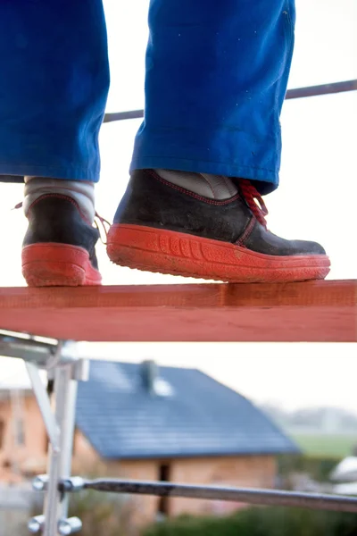 Homme dans un homme bleu sur un échafaudage — Photo