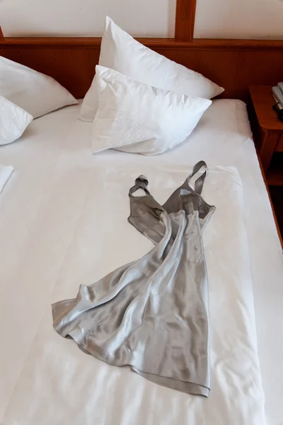 Nattkjole på senga på hotellrommet – stockfoto
