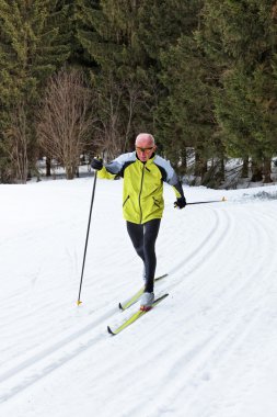 Senior cross country skiing during the winter clipart