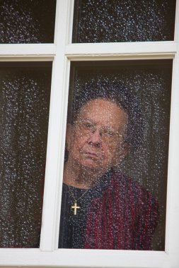 Old woman at the window with rain drops clipart