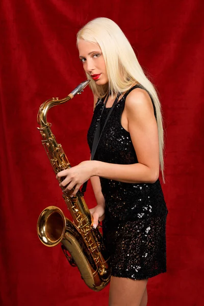 Молодая красивая женщина играет на саксофоне — стоковое фото