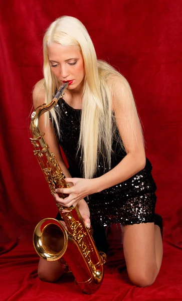 Молодая красивая женщина играет на саксофоне — стоковое фото