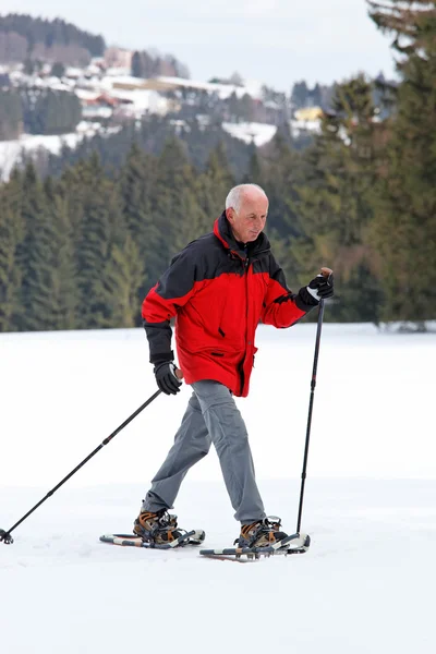 Senior when snowshoeing in winter — Stock Photo, Image