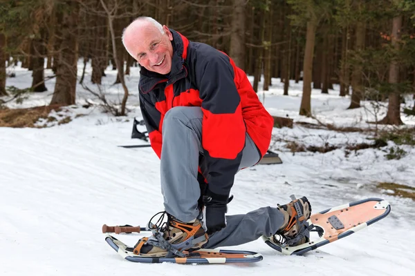 Senior quando snowshoeing no inverno — Fotografia de Stock