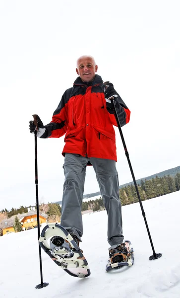 Senior beim Schneeschuhwandern im Winter — Stockfoto