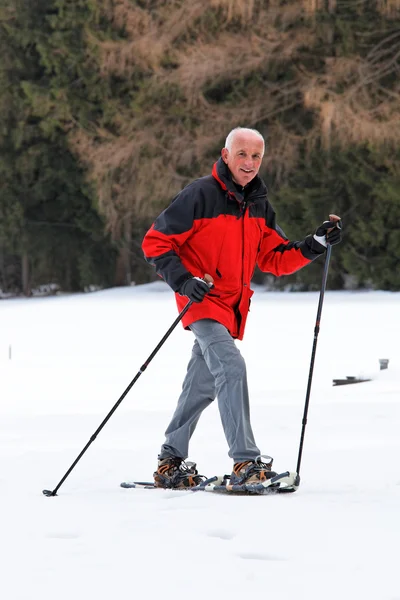 Senior quando snowshoeing no inverno — Fotografia de Stock
