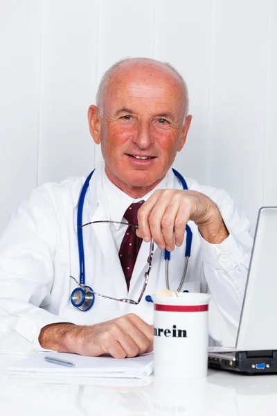 Arts met een stethoscoop en doctor's office laptop. — Stockfoto