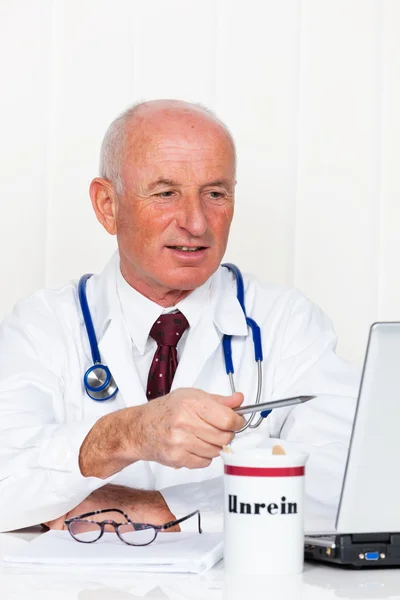 Médecin avec stéthoscope et ordinateur portable de bureau du médecin . — Photo