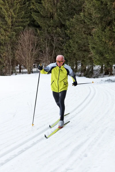 Senioren langlaufen tijdens de winter — Stockfoto