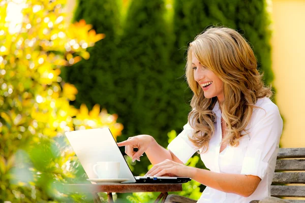 Женщина с ноутбуком в саду — стоковое фото