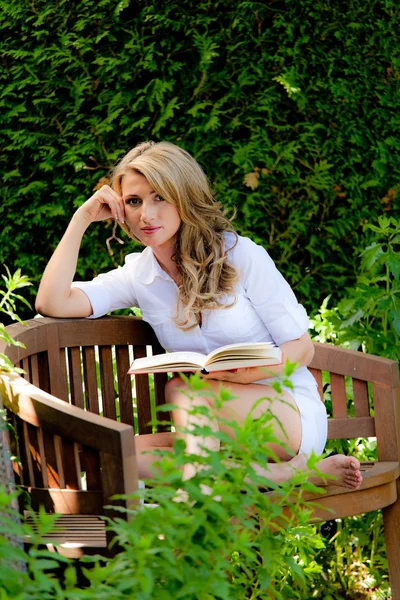 Femme lisant un livre dans le jardin — Photo